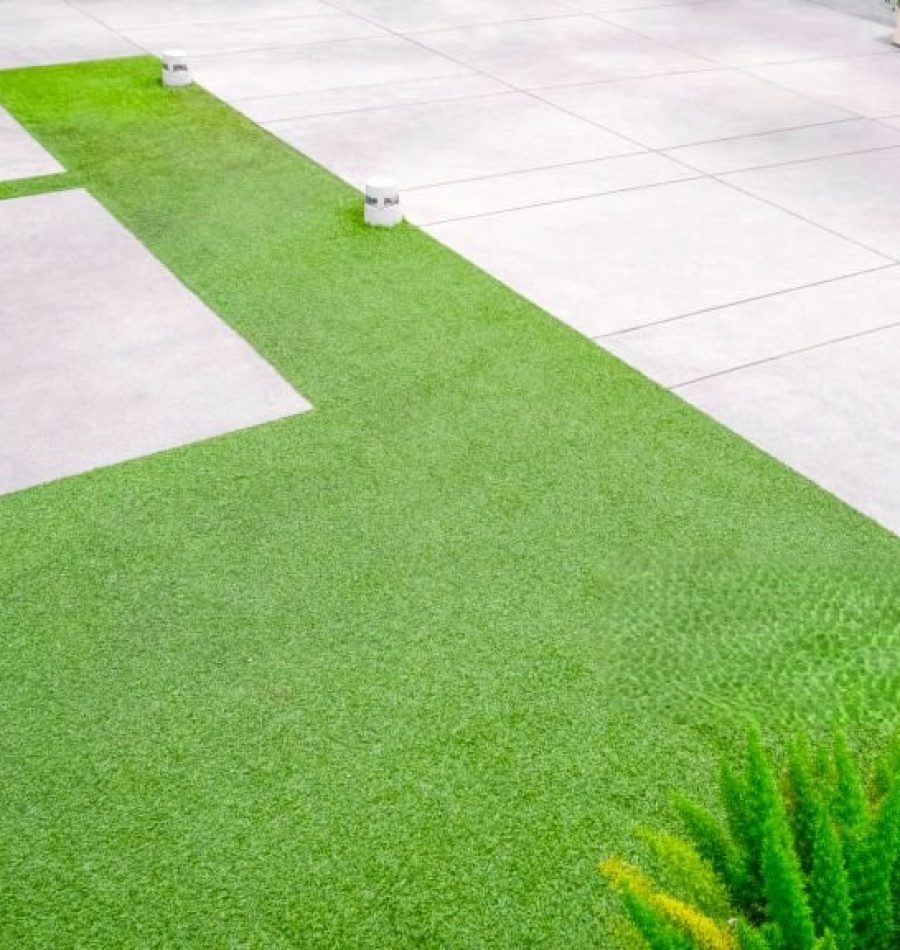 Artificial turf with gravel stone pavement decoration and ornamental plant in Home Gardening area, high angle view with copy space